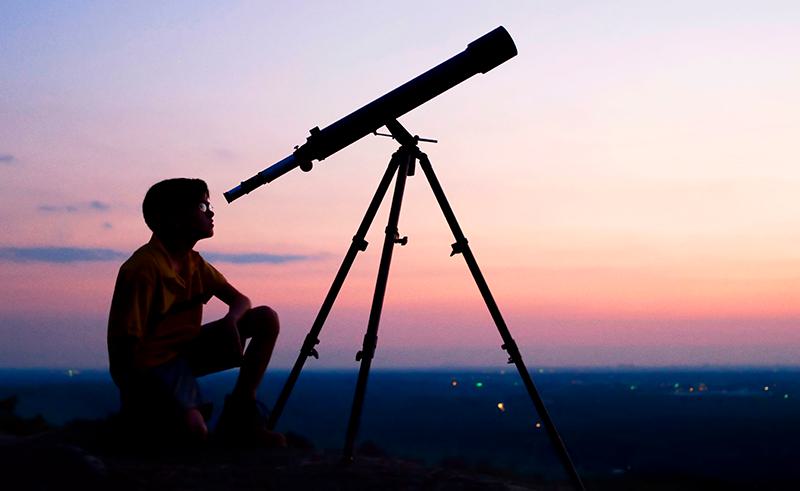 Person looking through telescope